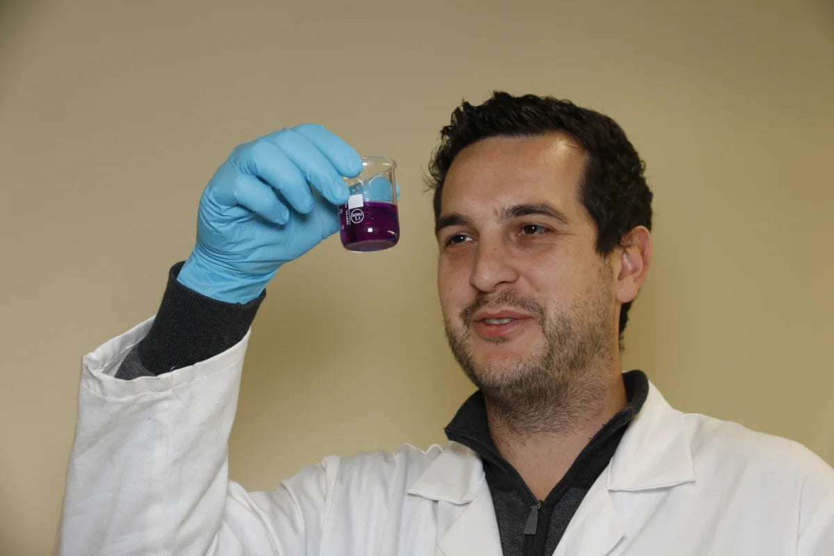 chemist looking at degreasing water sample having been titrated with our degreasing chemicals