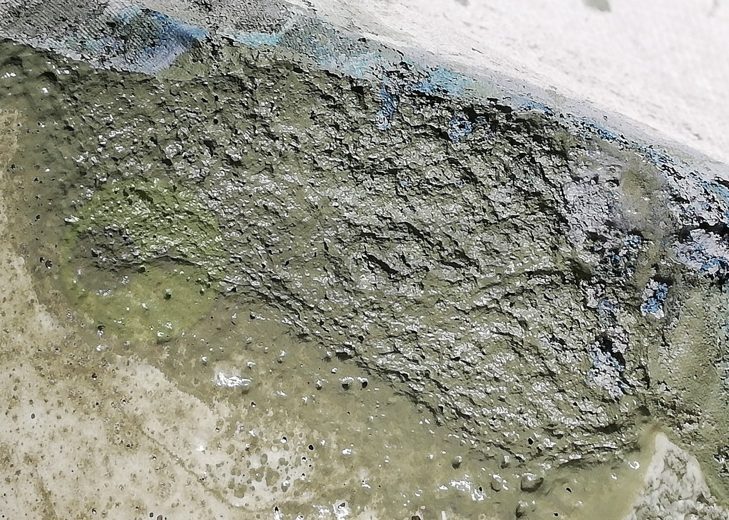 photo showing paint floating on surface of water in spray booth