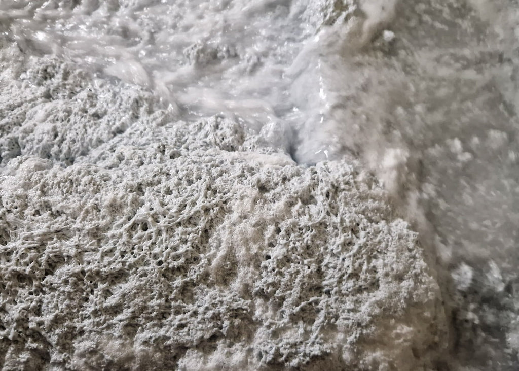 close up view of the water within an industrial spray booth that has been treated with our water treatment products to separate lacquer from the water so it can be filtered eliminating water disposal
