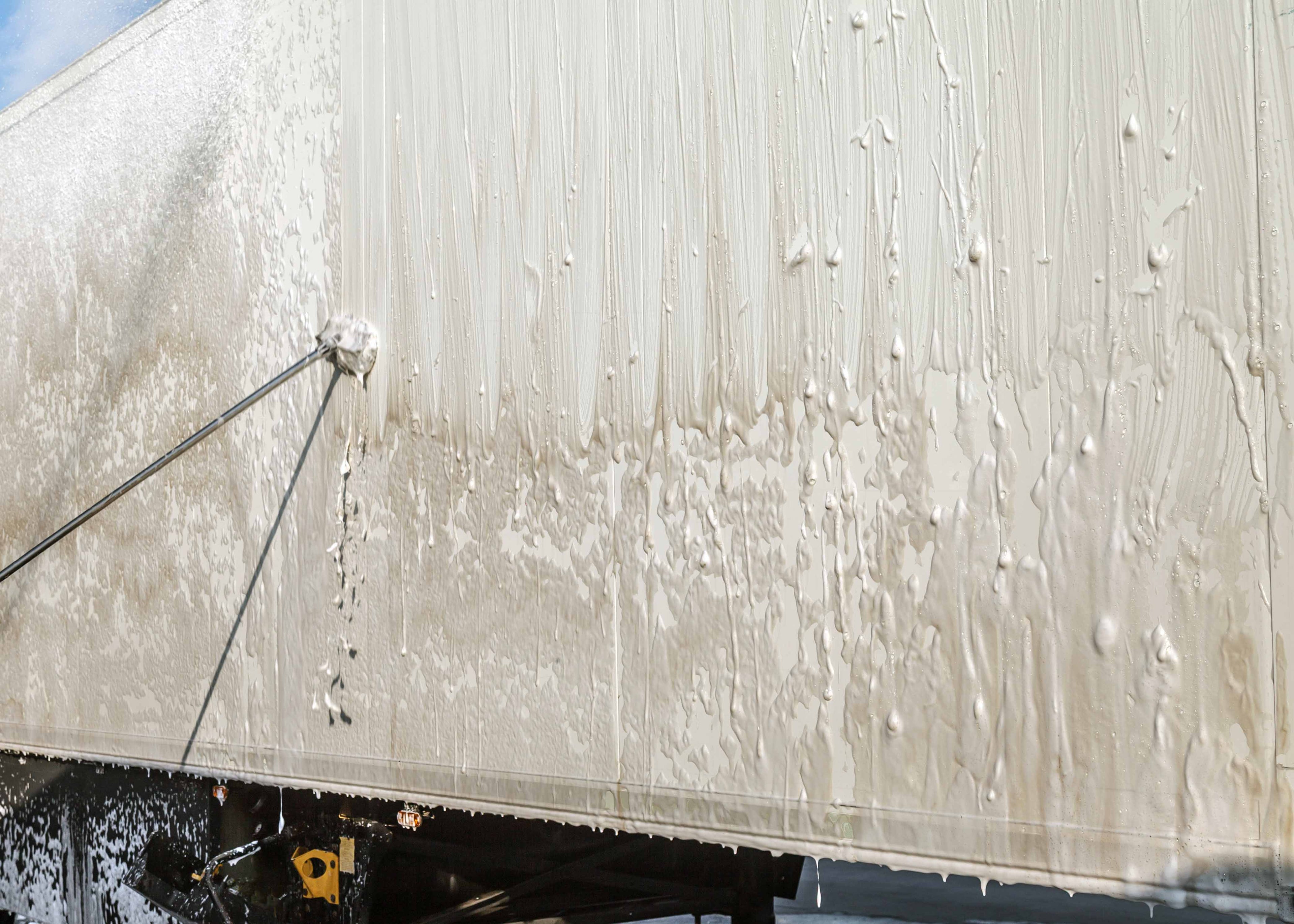 washing a lorry trainer with foaming detergent to remove dirt and traffic film